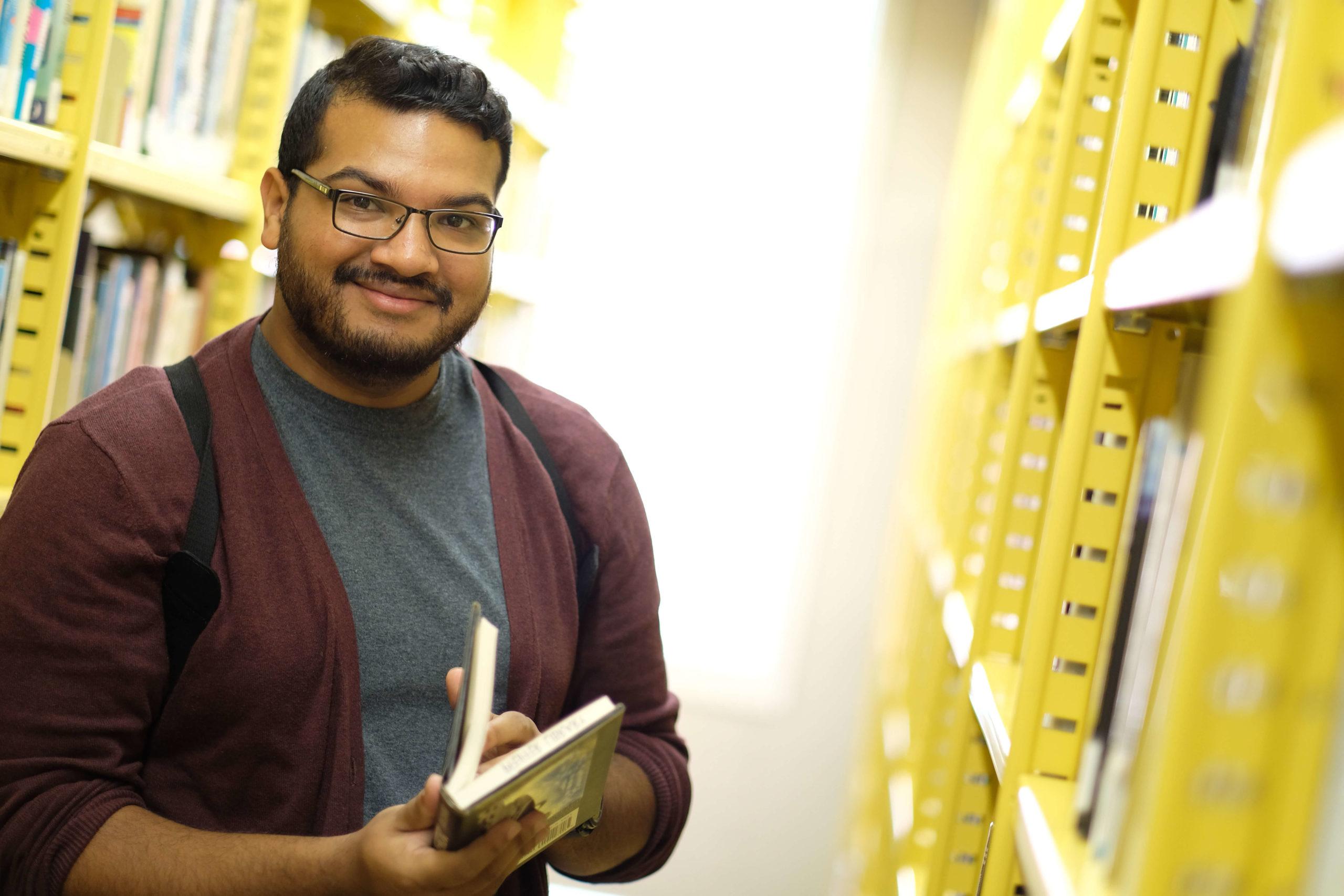 student in library stacks